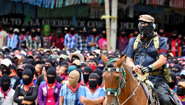 Subcomandante Marcos rides horseback in front of the Zapatista support base members in La Realidad during an homage to fallen compañero Galeano, who was killed in a paramilitary attack on May 2, 2014. | Photo: Tim Russo/Upside Down World